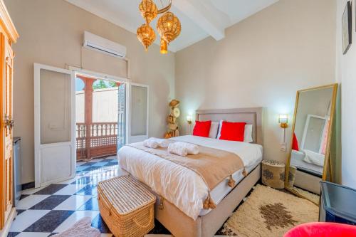 a bedroom with a large bed with red pillows at Dar Noubti in Marrakech