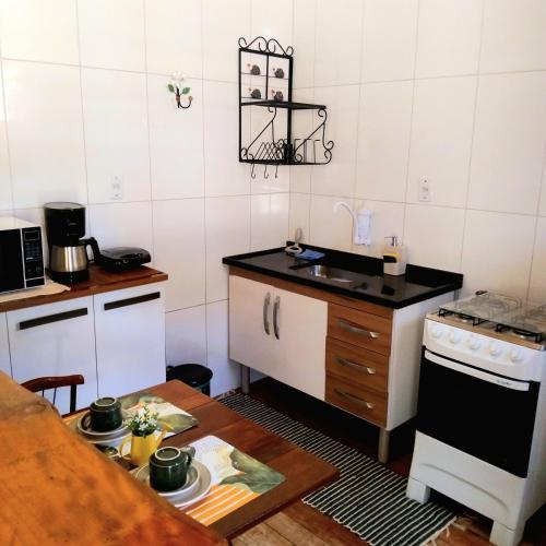a small kitchen with a stove and a sink at Recanto KAIRÓS in Visconde De Maua