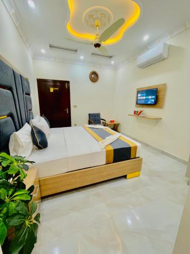a bedroom with a large bed and a tv at GO Luxury Grand Hotel in Lahore