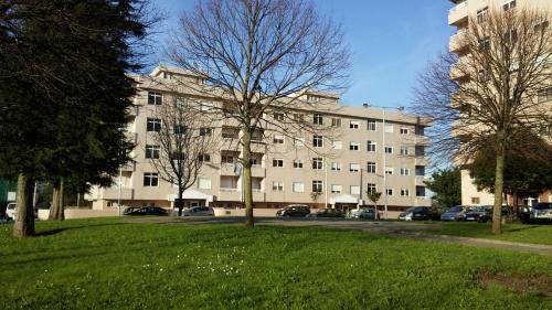 a large white building with cars parked in a park at House4U Vila Nova in Vila Nova de Gaia