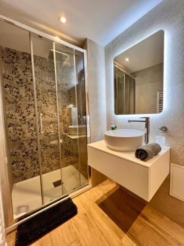 une salle de bain avec un lavabo et une douche en verre dans l'établissement Cours Massena, à Antibes