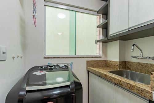 a kitchen with a trash can next to a sink at 200m da Praia II 1,8km Congresso Est Catolica 2025 II Wi-Fi l 4 Pessoas l Churrasqueira l Elevador 3º Andar l Cadeira de Praia e Guarda Sol l Vaga Garagem in Tramandaí