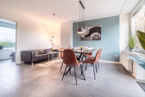ein Esszimmer mit Tisch und Stühlen und einer Couch in der Unterkunft WORKER'S HOME D30 - Reihenhaus mit 4 Schlafzimmern für 6 Personen in Wesel