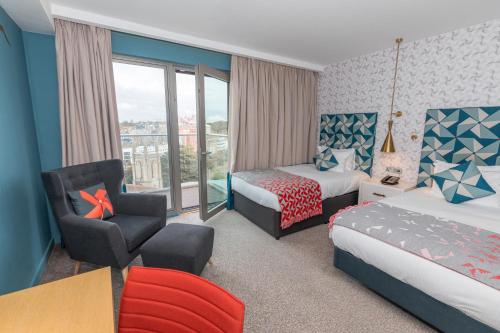 a hotel room with two beds and a chair at Hilton Bournemouth in Bournemouth