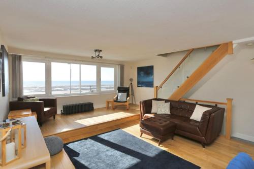 a living room with a couch and a chair at Fabulous beachfront 3 bed house with parking in Cleveleys