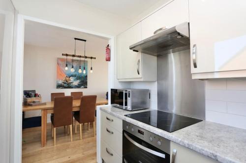 a kitchen with a counter top and a table with chairs at Fabulous beachfront 3 bed house with parking in Cleveleys