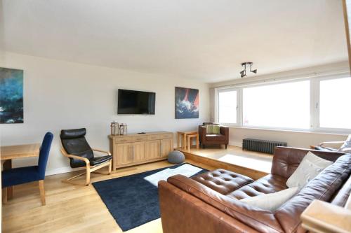 a living room with a couch and a tv at Fabulous beachfront 3 bed house with parking in Cleveleys
