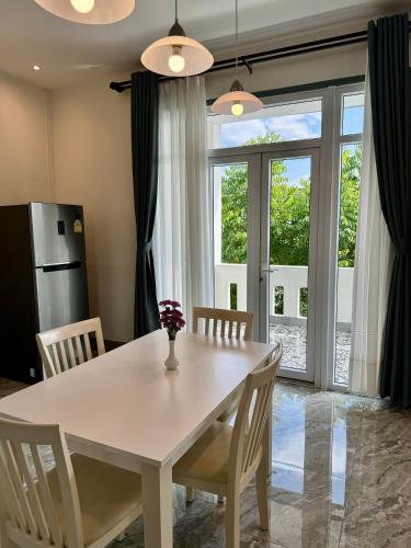 a dining room with a white table and chairs at Garden House Rice Field and Mountain View in Luang Prabang