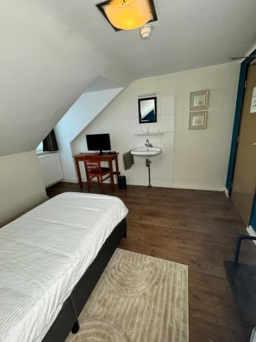a bedroom with a bed and a sink and a desk at Hotel Centraal in Someren