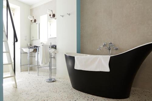 a bathroom with a black tub in a room at Prosper Maufoux - Château de Saint-Aubin in Saint-Aubin