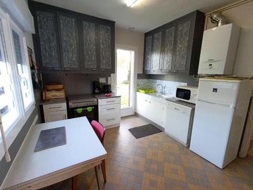 une cuisine avec des armoires blanches et un réfrigérateur blanc dans l'établissement Maison LE TOUQUET 6 pers, à Le Touquet-Paris-Plage