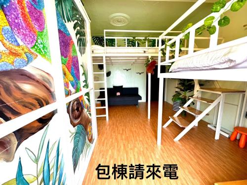 a dorm room with bunk beds and a mural at 番仔厝包棟民宿 in Xiaoliuqiu