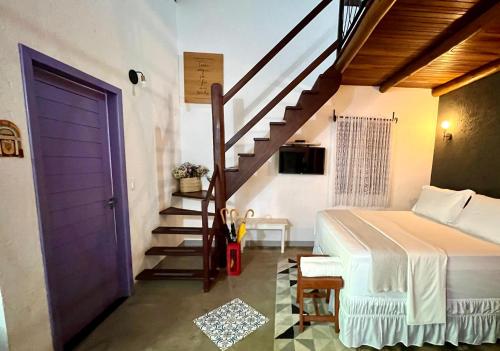 a bedroom with a bed and a staircase with a purple door at Chalés Calima in Lençóis