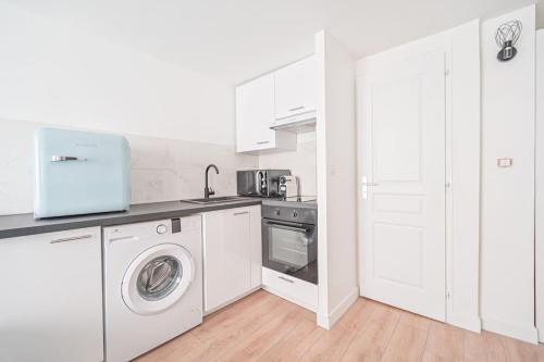 une cuisine blanche avec un lave-linge et un lave-linge dans l'établissement Studio Paris Centre - Republique, à Paris