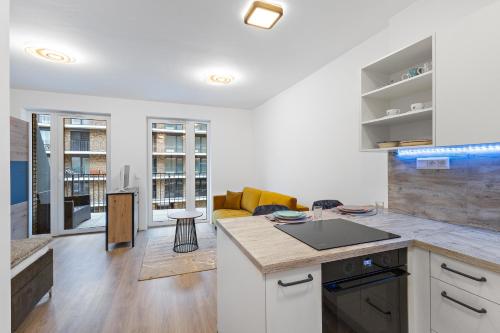a kitchen and a living room with a counter top at Moderný Apartmán s parkovaním v Novostavbe in Bratislava