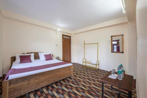 a bedroom with a large bed and a table at Kinnor Retreat in Sāngla