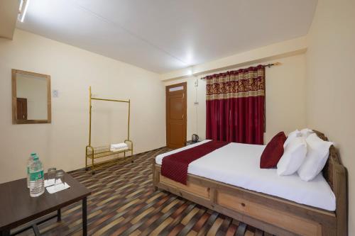 a bedroom with a bed and a table and a mirror at Kinnor Retreat in Sāngla