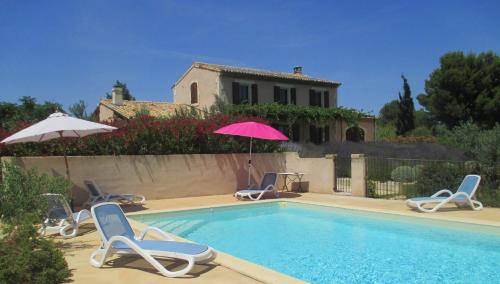 une piscine avec des chaises et un parasol ainsi qu'une maison dans l'établissement Villa avec piscine Saint Remy de Provence LS1-196, à Saint-Rémy-de-Provence