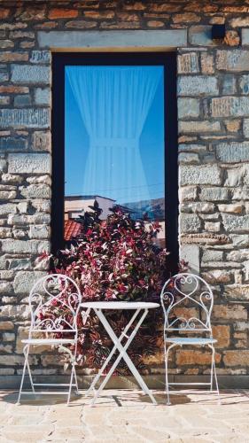 a table and two chairs in front of a window at Gogo Moustache Guest House in Përmet