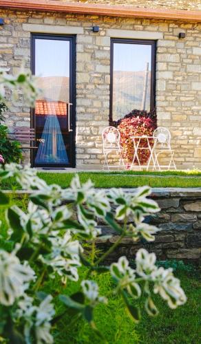 a house with two windows and a table and chairs at Gogo Moustache Guest House in Përmet