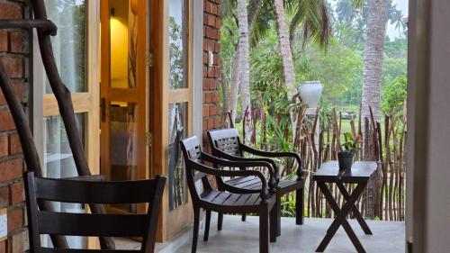 two chairs and a table on a porch at Whispering Wave Tangalle in Tangalle