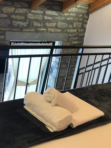 a stack of towels sitting on a table in front of a window at Gogo Moustache Guest House in Përmet