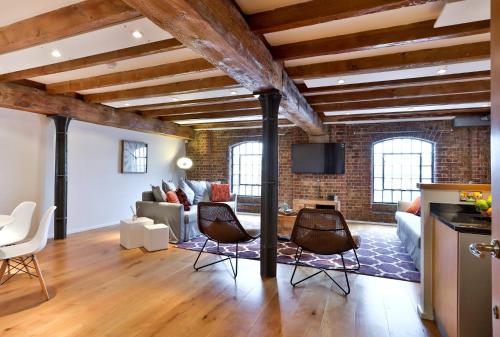 a living room with a brick wall at Wild Roses Serviced Apartments - ExCel Warehouse 1 in London