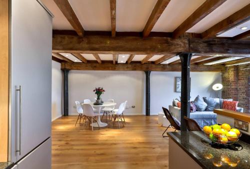 a kitchen and living room with a table and chairs at Wild Roses Serviced Apartments - ExCel Warehouse 1 in London