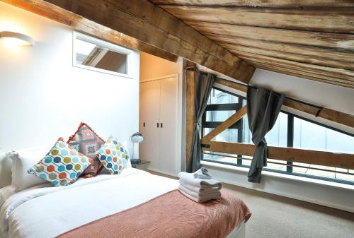 a bedroom with a bed and a large window at Wild Roses Serviced Apartments - ExCel Warehouse 1 in London