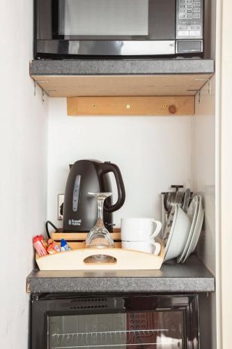 a kitchen counter top with a microwave and some utensils at Serene Waterfront Rooms - ExCel in London