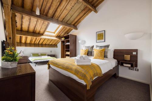 a bedroom with a large bed with a wooden ceiling at Wild Roses Serviced Apartments - ExCel Warehouse 2 in London