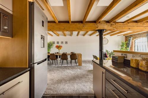 a kitchen with wooden ceilings and a dining room with a table at Wild Roses Serviced Apartments - ExCel Warehouse 2 in London