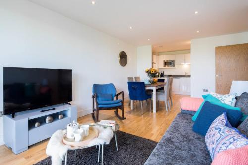 a living room with a couch and a tv at Wild Roses Serviced Apartments - Greenwich in London