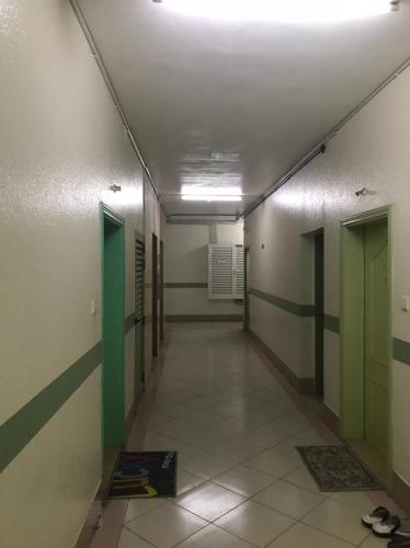 un pasillo vacío con paredes verdes y blancas en SBS B6 Building Apartment, en Sharjah
