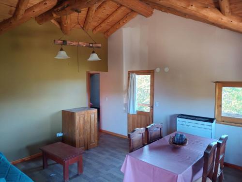 Un comedor con mesa y sillas en Departamento en los soles de montaña, en Villa Pehuenia