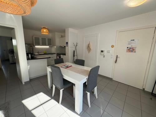 une cuisine et une salle à manger avec une table et des chaises blanches dans l'établissement Rêve By Dream Apartments, à Serris