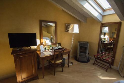 a room with a desk with a television and a room with a mirror at Relais La Colombara Spa & Wellness in Travo