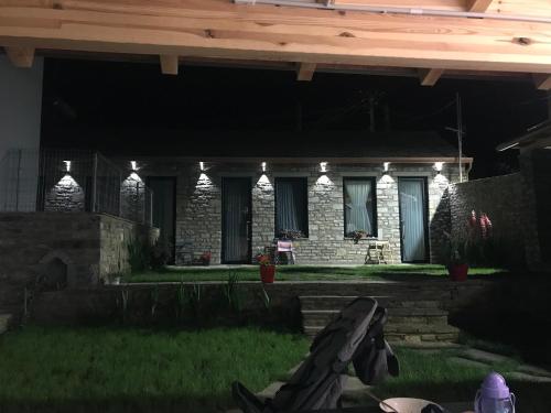 a house with lights on the front of it at night at Gogo Moustache Guest House in Përmet