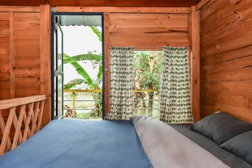 a bed in a wooden room with a window at Stella Mộc Châu homestay in Mộc Châu