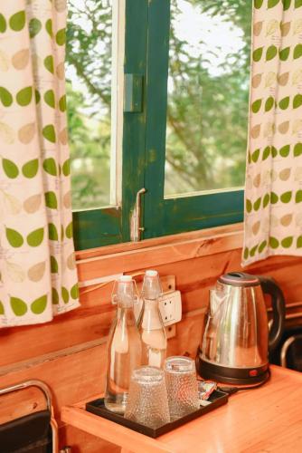 a counter with two glass bottles and a tea kettle at Stella Mộc Châu homestay in Mộc Châu