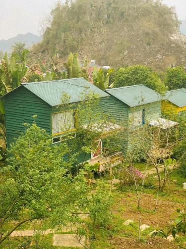 a green house with a mountain in the background at Stella Mộc Châu homestay in Mộc Châu