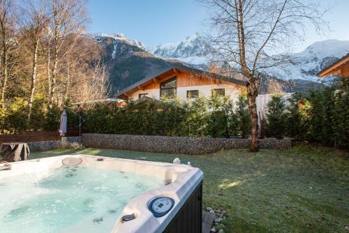 - un bain à remous dans une cour avec une maison dans l'établissement Chalet Arve - Alpes Travel - Chamonix - Sleeps 10, à Chamonix-Mont-Blanc