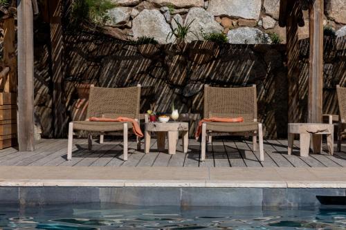 two chairs and a table next to a swimming pool at Résidence U Frusteru in Propriano