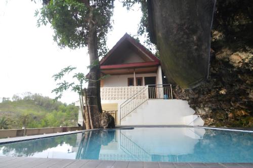 a house with a swimming pool in front of a building at Villa Kopiori in Yogyakarta
