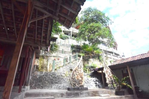 a building with two sculptures in front of a building at Villa Kopiori in Yogyakarta