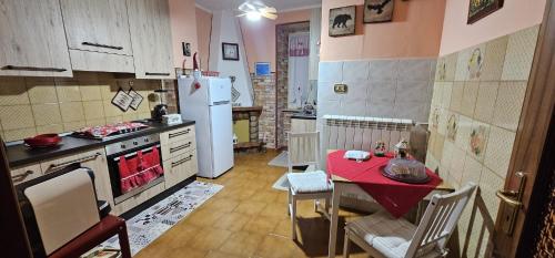 a small kitchen with a table and a refrigerator at Casa Lory in Pescina