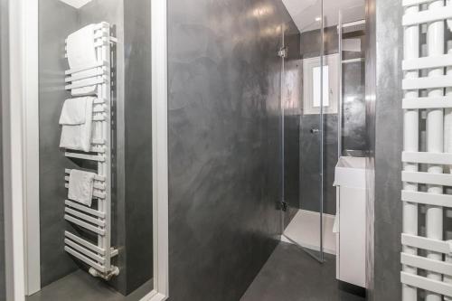 a bathroom with a walk in shower and a glass door at Studio Arco Rustic in Zagreb