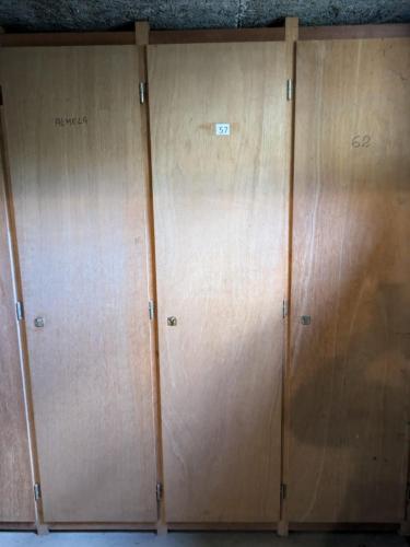 - une rangée de casiers en bois dans un dortoir dans l'établissement Petit nid douillet , T1 avec cuisine indépendante, au calme, proche centre ville, à Luchon