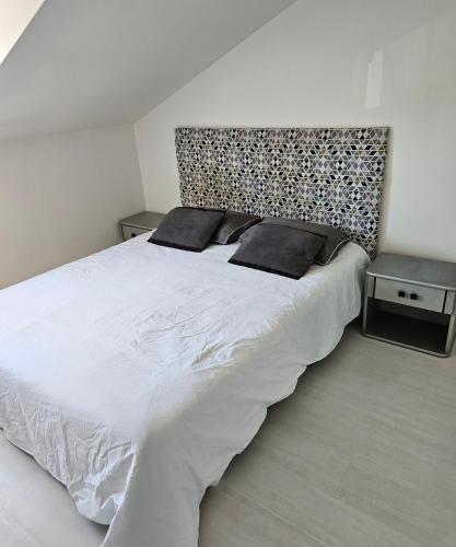 une chambre avec un grand lit blanc avec deux oreillers dans l'établissement Les 6 chemins, à Saint-Nazaire