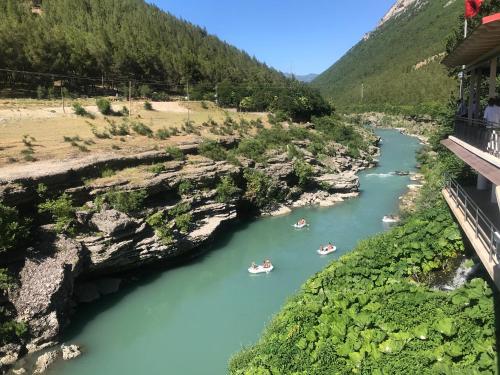 people in boats on a river in a canyon at Gogo Moustache Guest House in Përmet